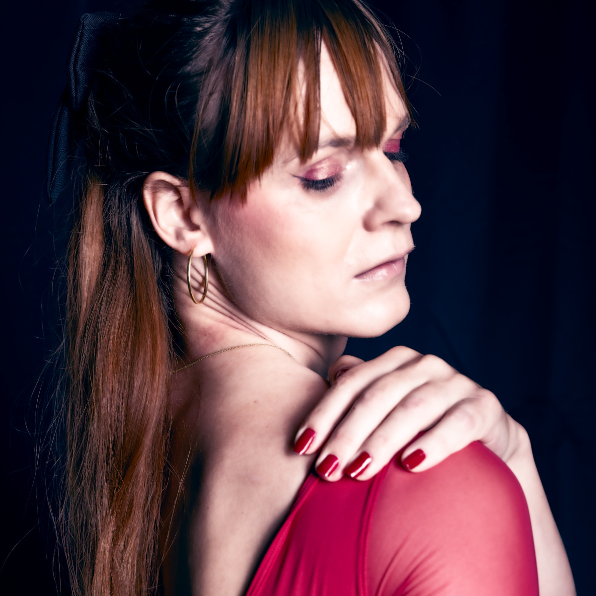 A professional picture of me looking wistfully over my shoulder in a red ballet body